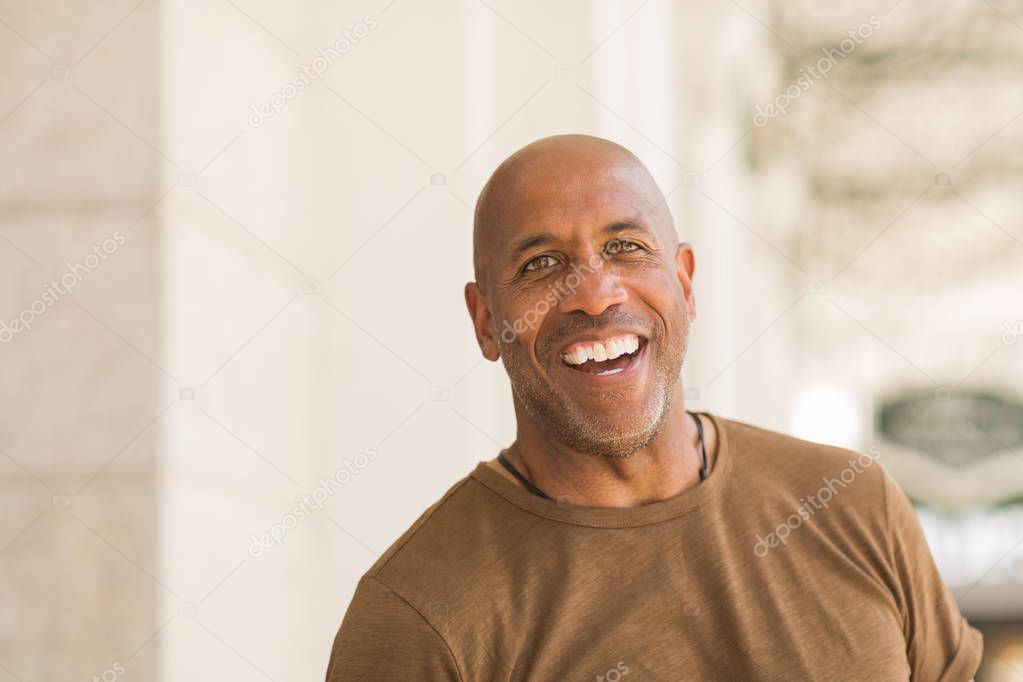 Mature African American man smiling wearing glasses.