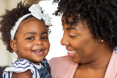 Afro-Amerikan ailesi. Anne ve kızı evde gülümseyen.