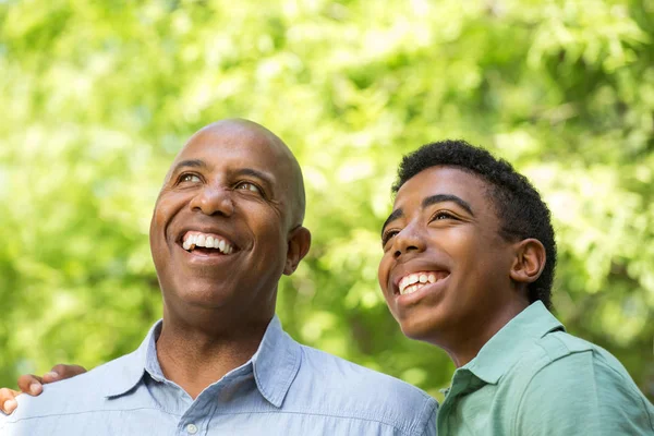 Afrikaanse Amerikaanse vader praten met tiener zoon. — Stockfoto