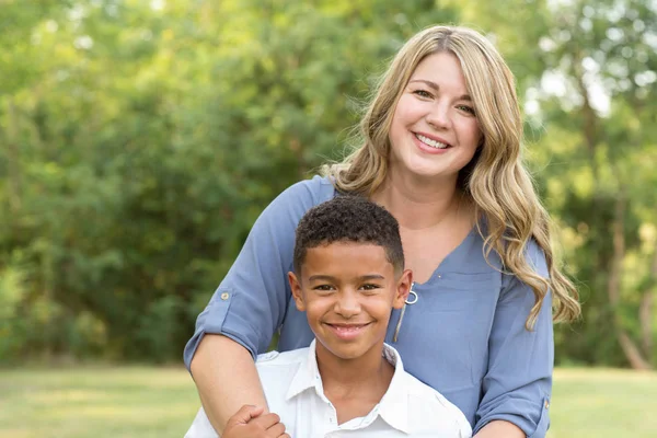 Moeder en zoon lachen en spelen in het park. — Stockfoto