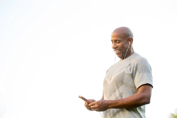 Fit afrikanisch-amerikanischer Mann hört Musik. — Stockfoto