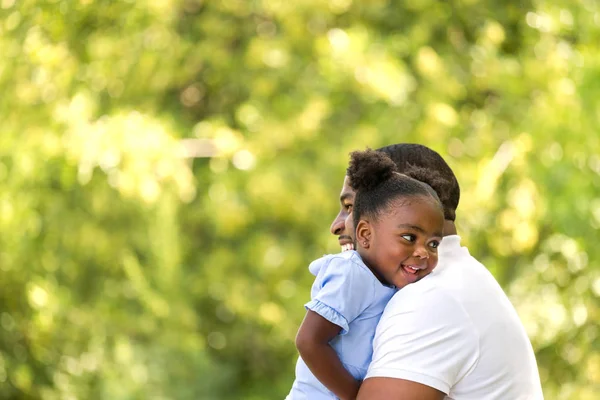 Padre afroamericano abrazando y sosteniendo a su niña . — Foto de Stock