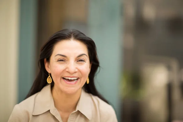 Glückliche hispanische Frau, die lächelt und draußen steht. lizenzfreie Stockbilder