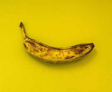 Bekar, olgun muz ve sarı bir arka plan.
