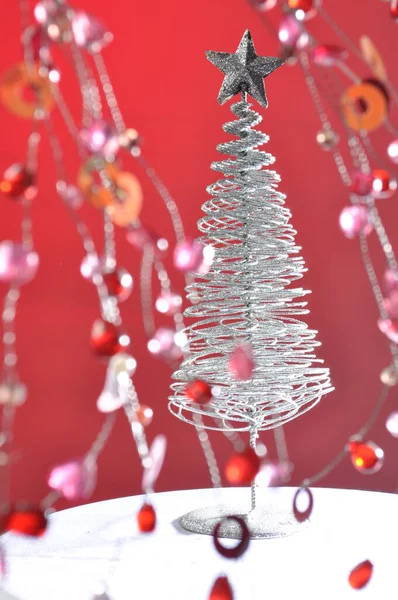 Pembe arka planda çelenkleri olan Noel ağacı