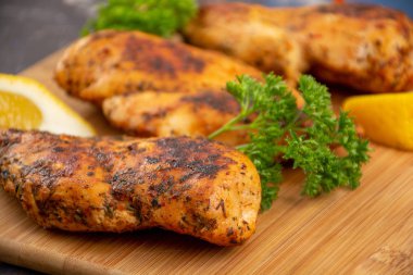 Ahşap kesme tahtası üzerinde ızgara tavuk göğsü