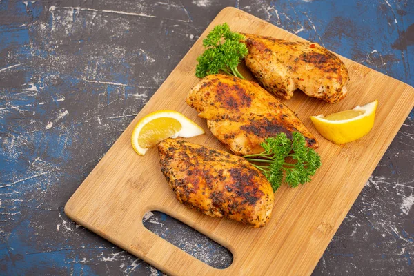 Grilled chicken breast on a wooden cutting board