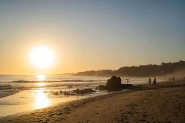 Falesia Sahili 'nde altın kum ve Atlantik Okyanusu' nda gün batımında kocaman bir güneş. Olhos de Agua, Algarve, Portekiz.