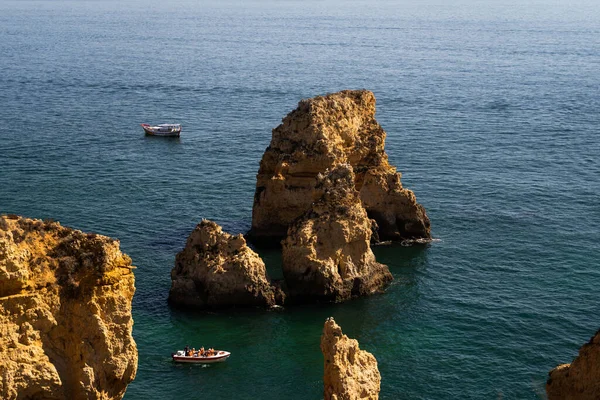Ponta da Piedade 'nin güzel uçurumları. Kireçtaşı kayasının doğal oluşumu. Ortasında bir tekne var. Lagos, Algarve, Portekiz.