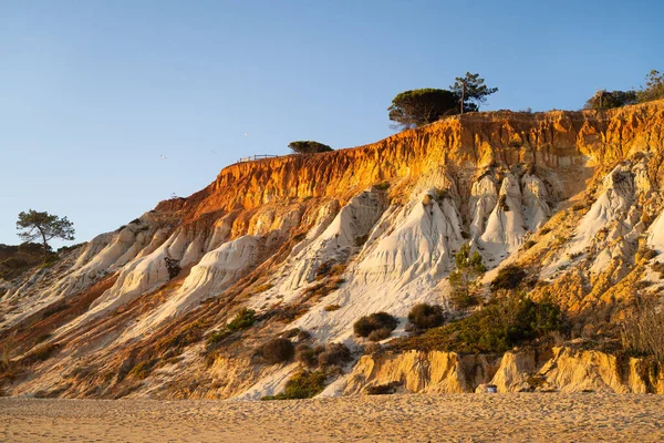 Falesia Sahili 'nin turuncu kumulları gün batımında. Albufeira, Algarve, Portekiz.
