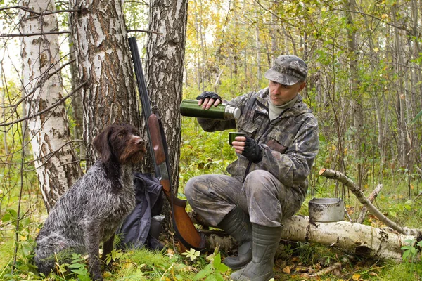 hunter at halt pours tea from a thermos