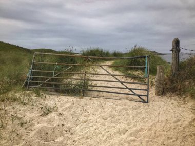 İskoçya 'nın Iona adasındaki plajlardan birinde metal bir kapı.