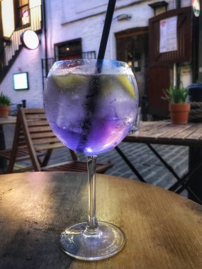 Glasgow 'da bir barın dışındaki masada büyük yuvarlak bir bardakta büyük mor bir kokteyl.