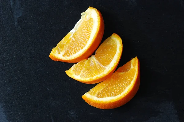 Slices of juicy orange on a black background.