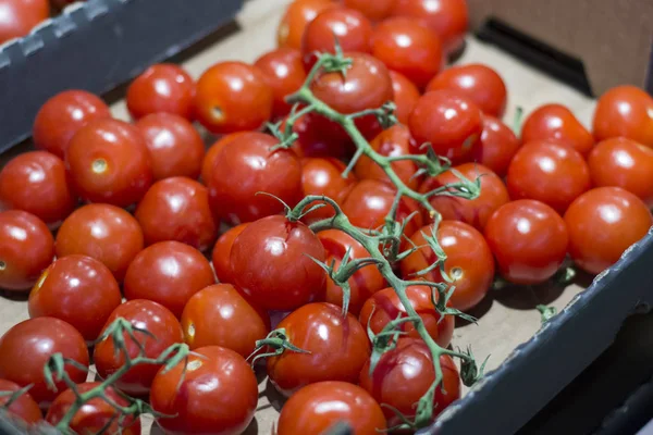 A lot of cherry tomatoes in a box in a supermarket.