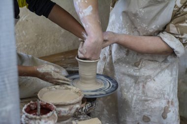 Bir çömlekçi bir çocuk nasıl bir pot kil yapmak için öğretir..