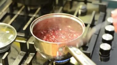 Bir gaz sobası Berry vişne sosu yemek.