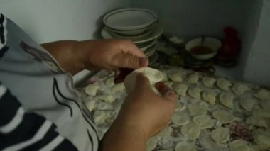 Bir kadın bir sürü köfte süzme peynir ile yapar.