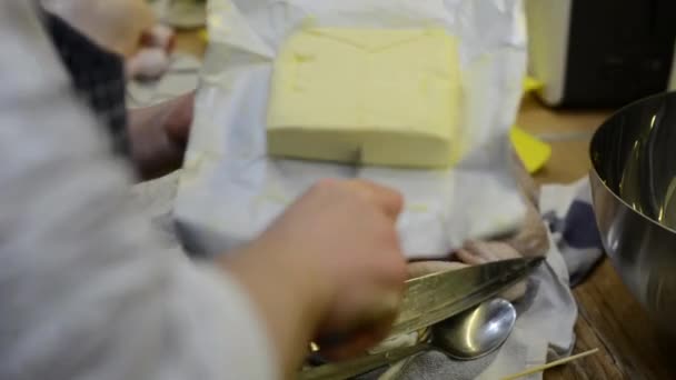 Das Mädchen Schneidet Beim Kochen Ein Stück Butter — Stockvideo