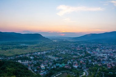 Şehrin, dağların ve gün batımının güzel manzarası.