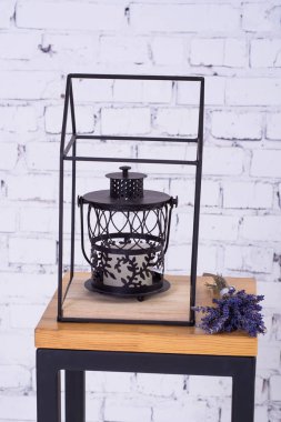 Siyah metal lamba ve küçük bir ahşap masada lavanta bir buket.