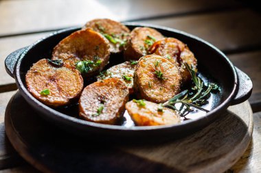 Masada küçük bir dökme demir tavada biberiye ile kızarmış patates.