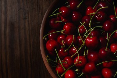 Tahta masadaki bir kasede sulu kirazlar - üst manzara