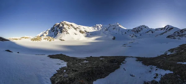 Montanhas nevadas do Cáucaso ao pôr do sol com céu azul — Fotografia de Stock