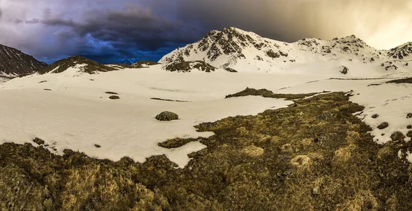 Montanhas nevadas do Cáucaso ao pôr-do-sol com tempestade no céu — Fotografia de Stock