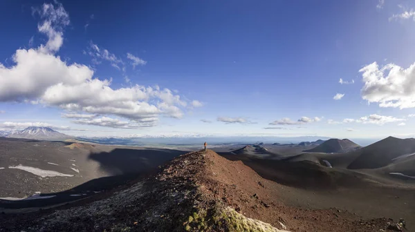 Hombre de pie sobre escoria volcánica con vista a volcanes nevados — Foto de Stock