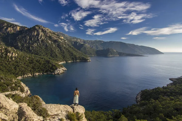 Hombre de pie sobre un acantilado en las montañas cerca del mar mediterráneo —  Fotos de Stock