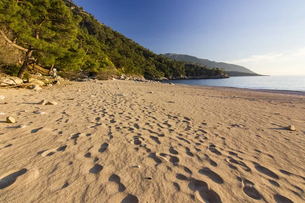 Solnedgång på sandstranden vid Medelhavet med berg på bakgrund — Stockfoto