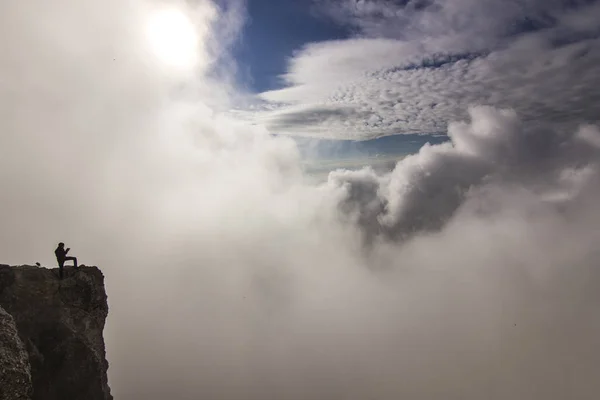 Eller yukarı uçurumdan bulutların üzerinde duran kızla — Stok fotoğraf