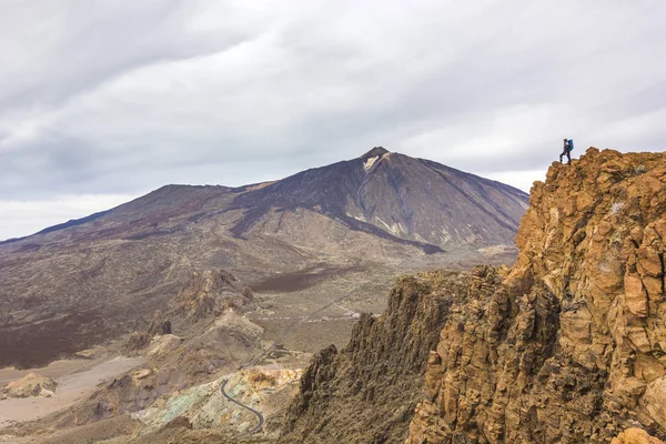 Hombre de pie sobre rocas con volcán de teida en el fondo — Foto de Stock