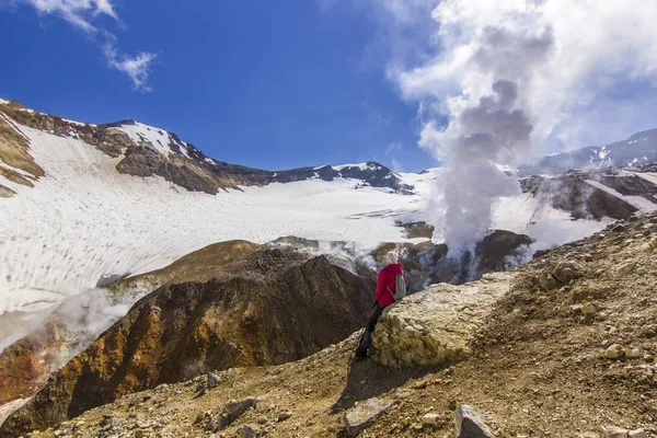 Lány ül gőzölgő kráter aktív vulkán közelében fedezi a hó — Stock Fotó