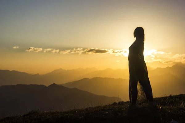 Silhouete lány ruha állva fű naplemente-hegység — Stock Fotó