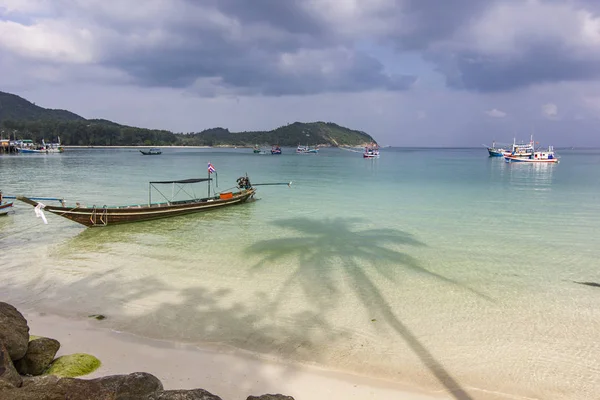 Blauer Ozeanstrand mit Booten und Palmenschatten auf dem Wasser in Phangan Island — Stockfoto