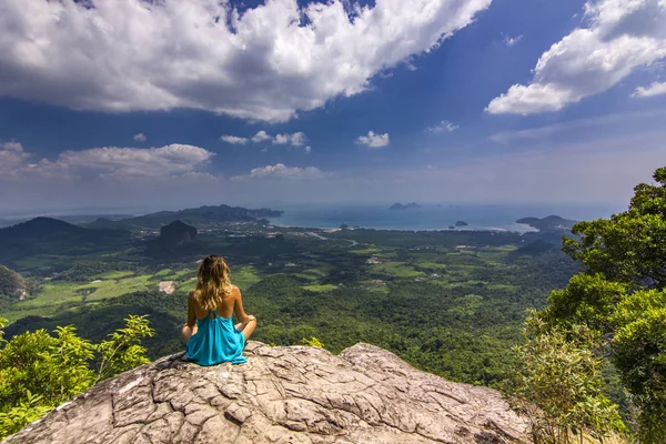 Ragazza seduta sulla roccia alla luce del giorno con le montagne sotto — Foto Stock