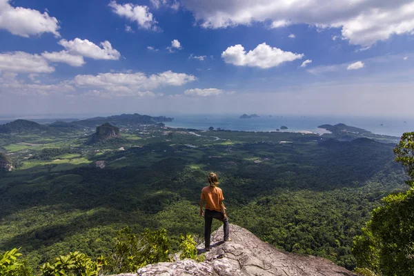 Pria berdiri di atas batu saat matahari terbenam dengan gunung-gunung di bawah — Stok Foto