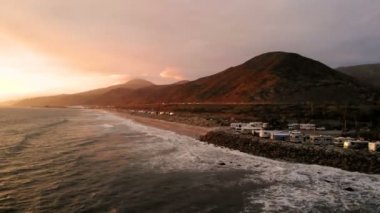 Karavan Parkı (kamp) sahilinde, California. Okyanus. California günbatımı sırasında. Yukarıdan, su üzerinde uçan uçak havadan görünümü.