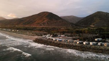 Karavan Parkı (kamp) sahilinde, California. Okyanus. California günbatımı sırasında. Yukarıdan, su üzerinde uçan uçak havadan görünümü.