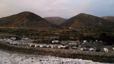 Karavan Parkı (kamp) sahilinde, California. Okyanus. California günbatımı sırasında. Yukarıdan, su üzerinde uçan uçak havadan görünümü.