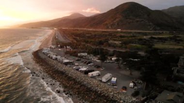 Karavan Parkı (kamp) sahilinde, California. Okyanus. California günbatımı sırasında. Yukarıdan, su üzerinde uçan uçak havadan görünümü.
