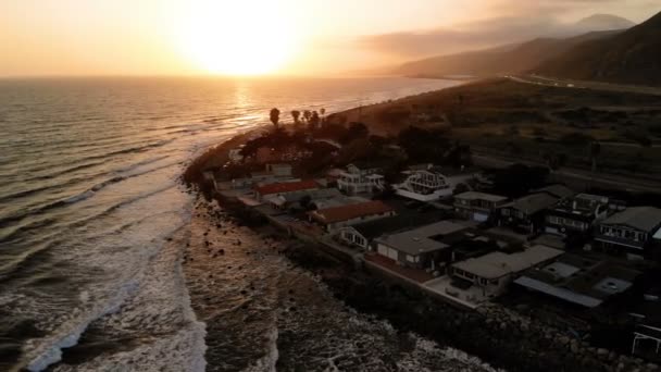 Vue aérienne des maisons de plage le long de la côte du Pacifique en Californie. Immobilier pendant le coucher du soleil. D'en haut, drone volant au-dessus de l'eau .