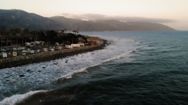 Karavan Parkı (kamp) sahilinde, California. Okyanus. California günbatımı sırasında. Yukarıdan, su üzerinde uçan uçak havadan görünümü.