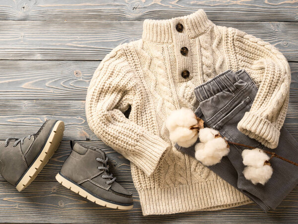 Мода детская одежда, обувь (вязаный свитер, джинсы, замшевые сапоги). Одежда для мальчика. Зимняя, осенняя коллекция. Органический хлопок. Вид сверху, плоский
