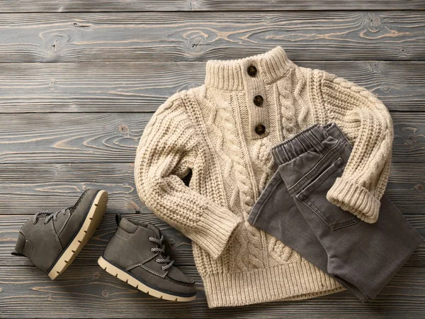 Fashion children\'s clothing, shoes (knit sweater, jeans, suede boots). Outfit for little boy. Winter, autumn collection. Organic cotton. Top view, flat lay