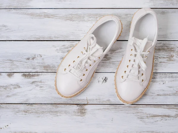 Damenschuhe (weiße Turnschuhe) auf Holzgrund. Frühlingssommer — Stockfoto