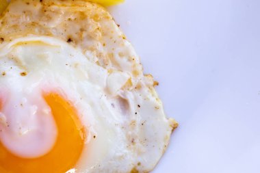 Kızarmış yumurta ve beyaz tabakta patates.