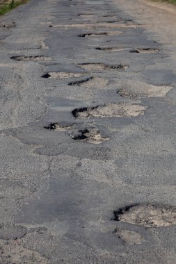 Asfalttaki deliklerle dolu yol. Tümsek. 